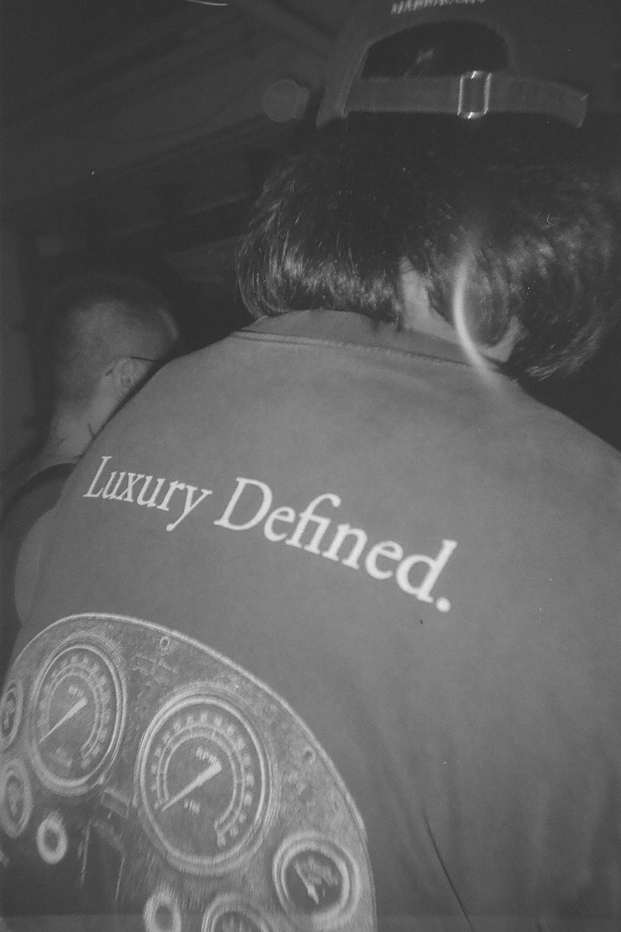 Guest seen from behind in a printed shirt, shot in black and white