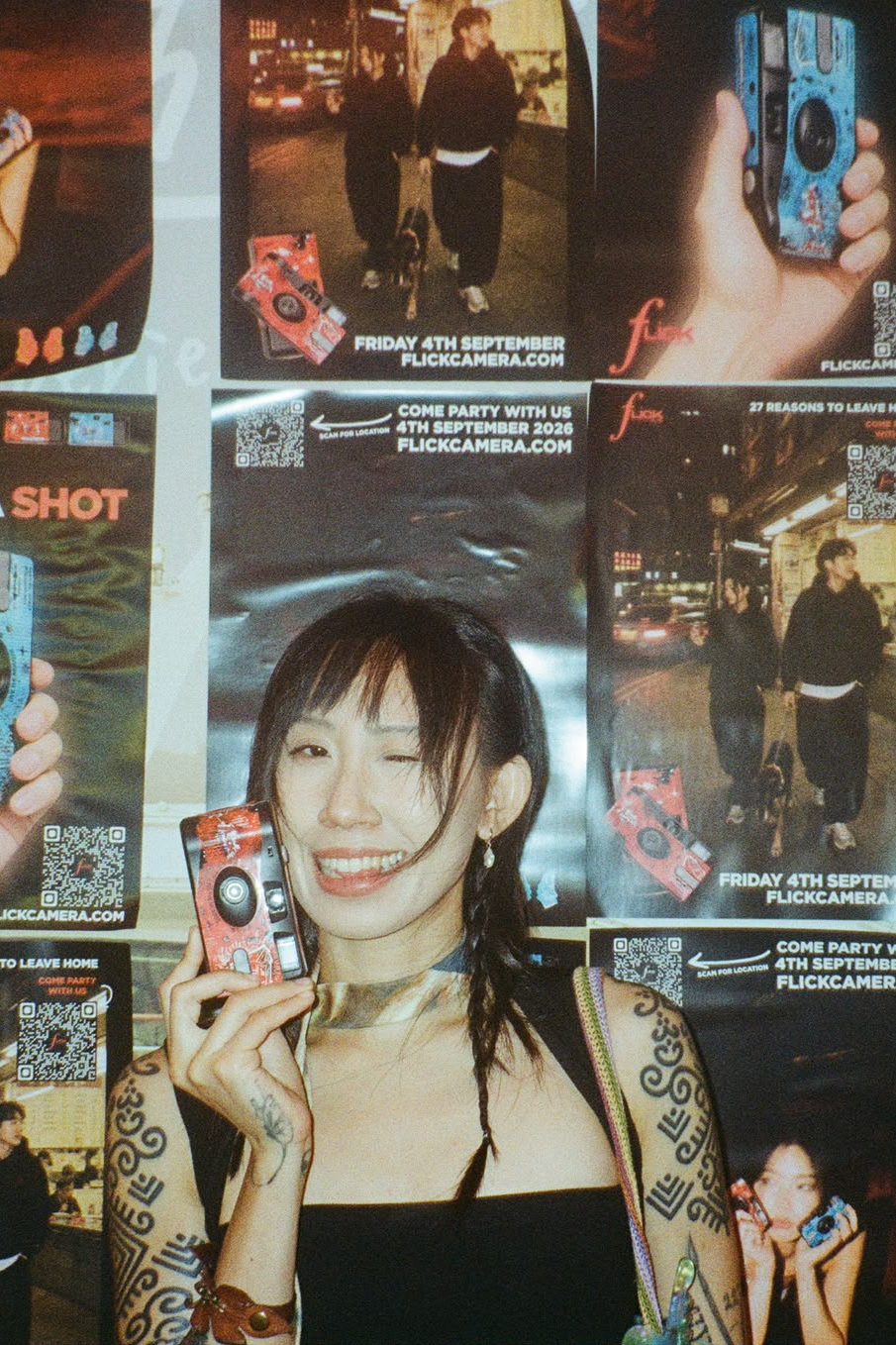 Guest winking as she holds up a red Flick camera
