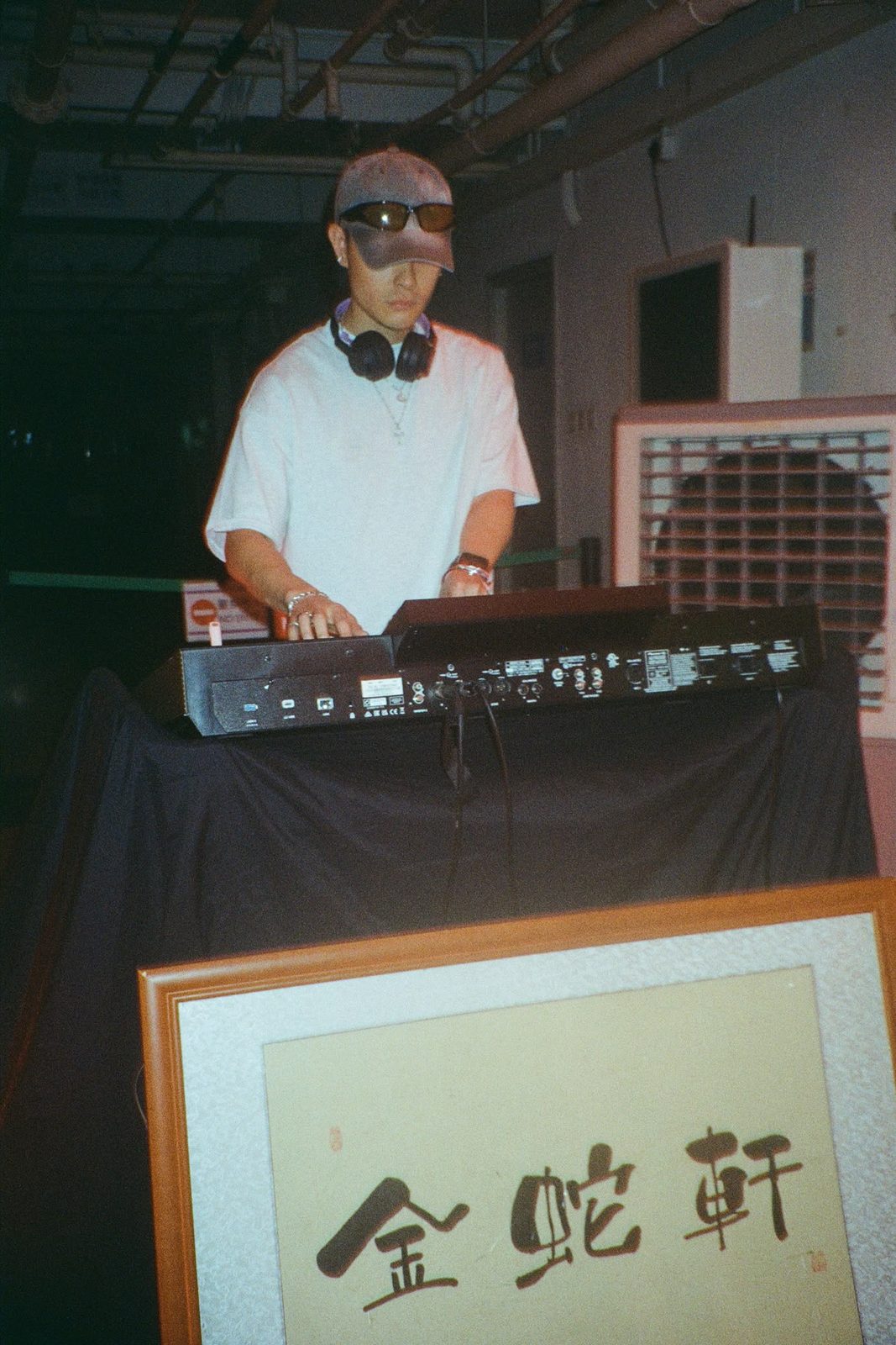 DJ playing at the launch party beside the Golden Snake sign