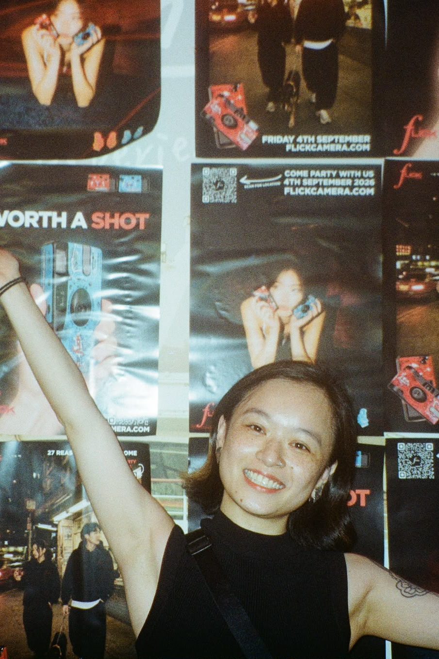 Guest throwing an arm up in front of the poster wall